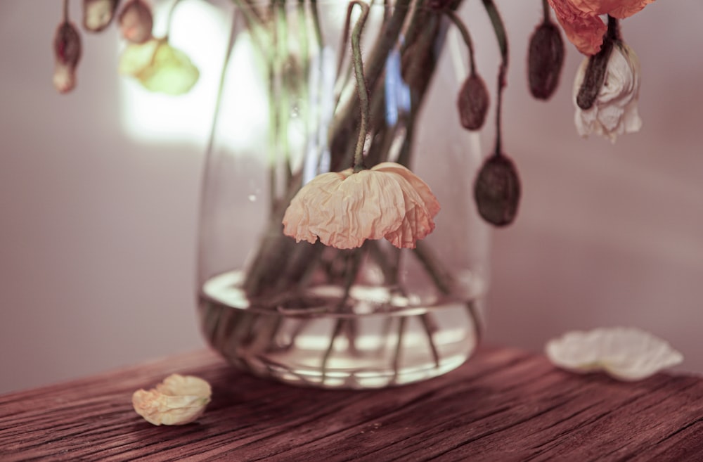 a vase filled with flowers on top of a wooden table