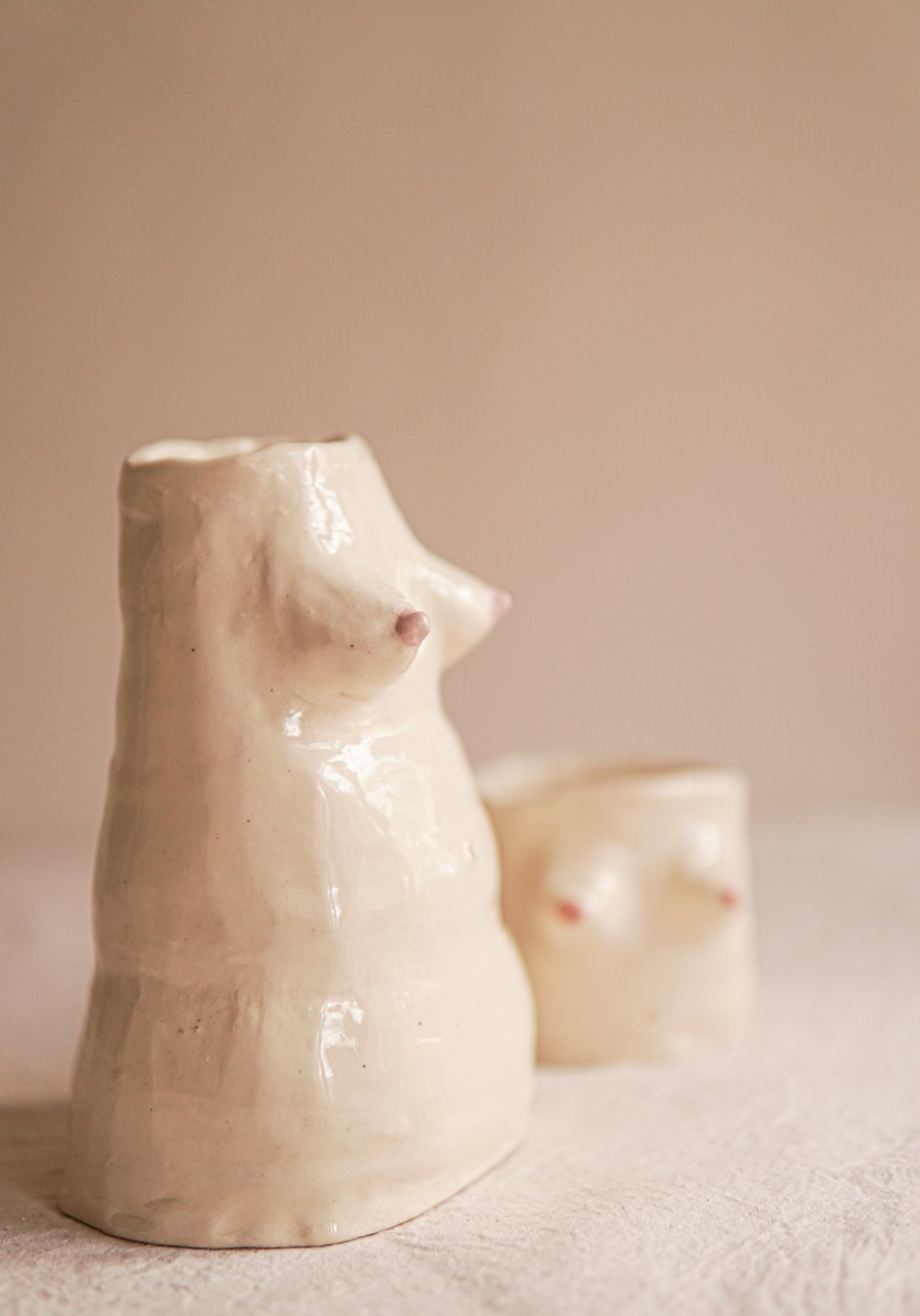 two ceramic bears sitting on a bed next to each other