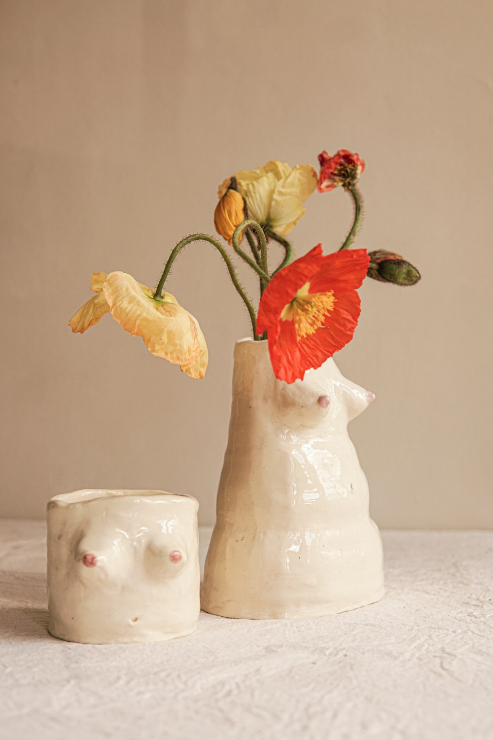 a white vase with a flower in it