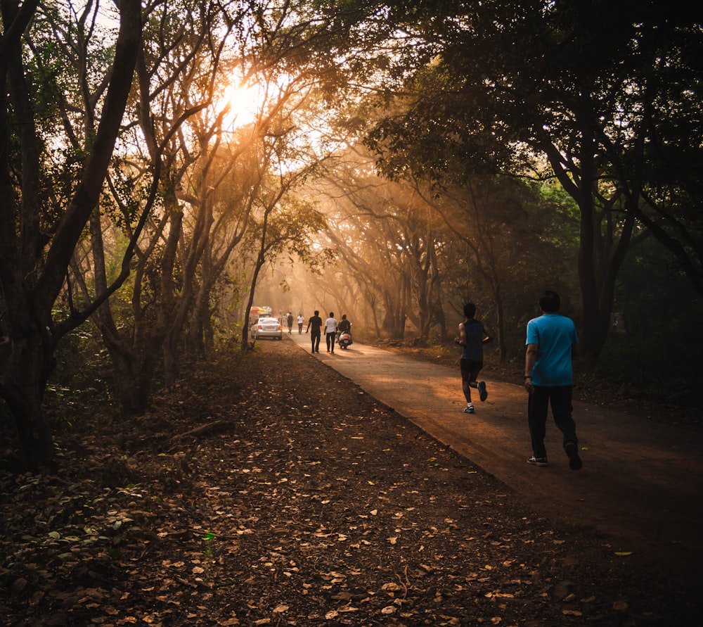 a group of people walking down a dirt road