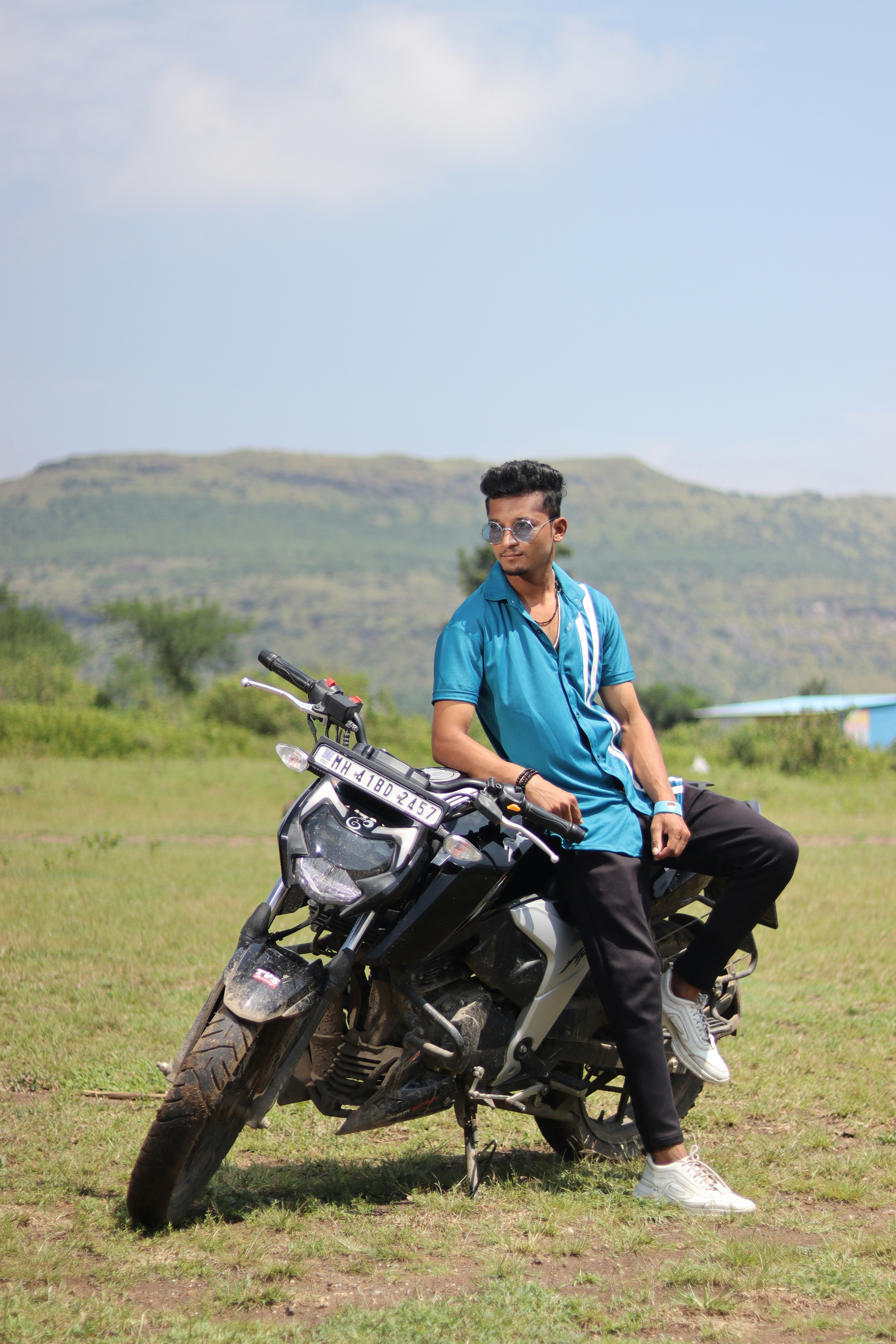 a man sitting on a motorcycle in a field
