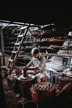 Employees gathered around a pottery wheel, shaping clay with focused smiles in a cozy studio.