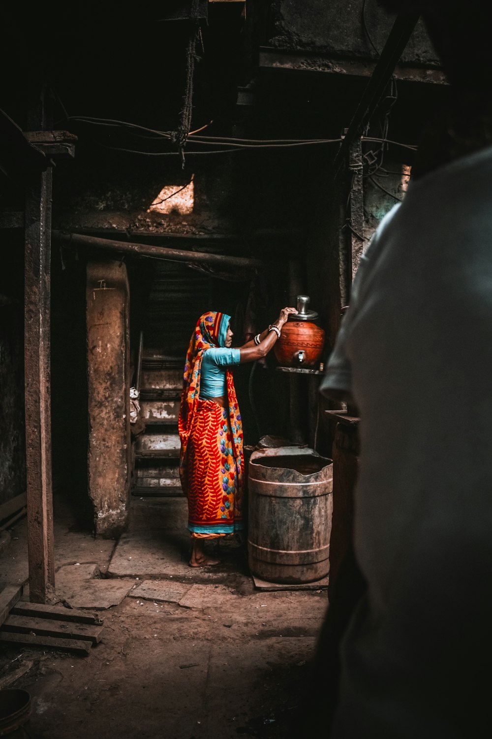 Une femme vêtue d’un sari coloré verse de l’eau