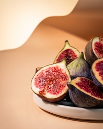 a white plate topped with sliced figs on top of a table