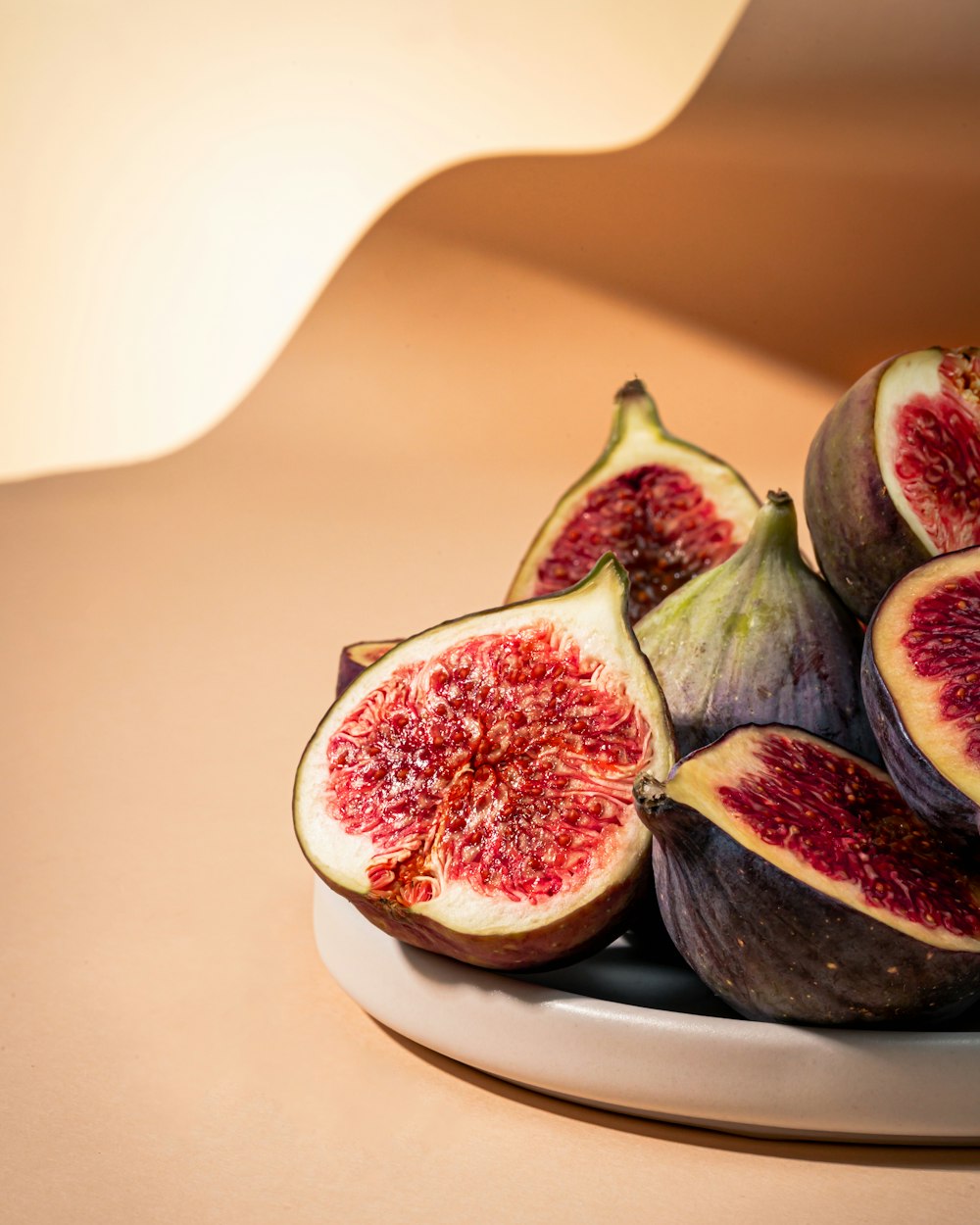 a white plate topped with sliced figs on top of a table