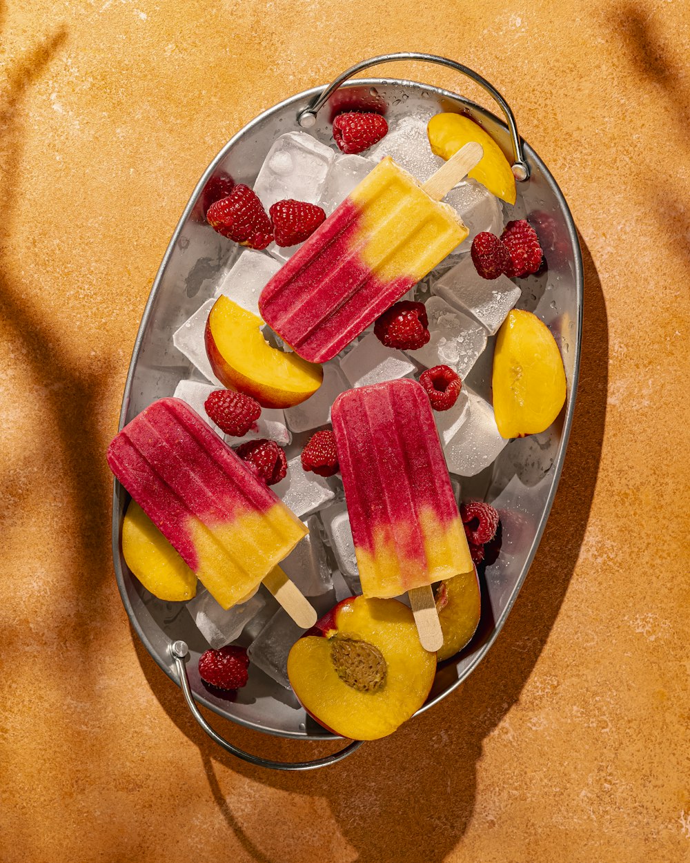 a metal pail filled with fruit and ice cream