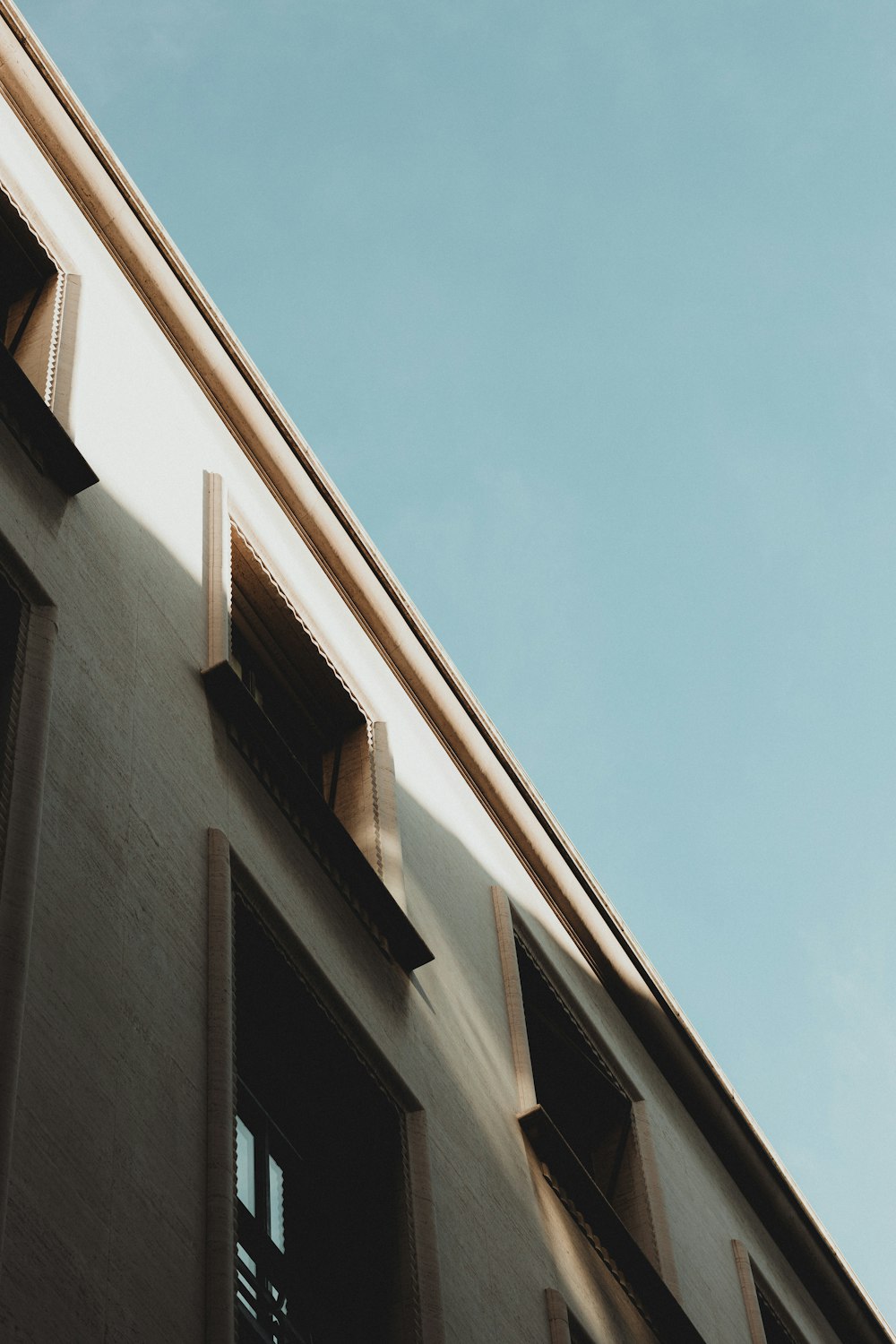 a close up of a building with windows and a sky background