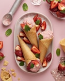 three cones of ice cream with strawberries on a plate