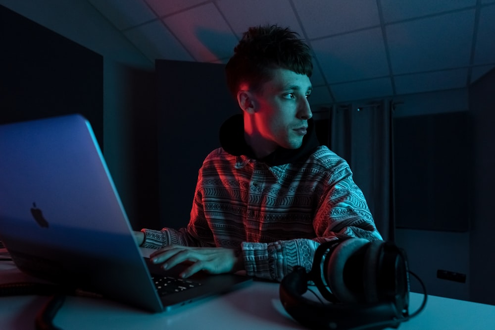 um homem sentado na frente de um computador portátil