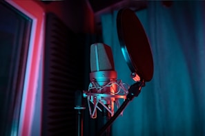 Microphone setup in a cozy recording booth with subtle blue lighting.