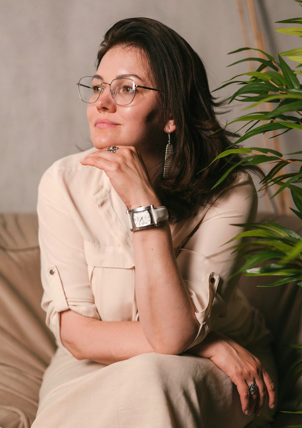 a woman wearing glasses sitting on a couch