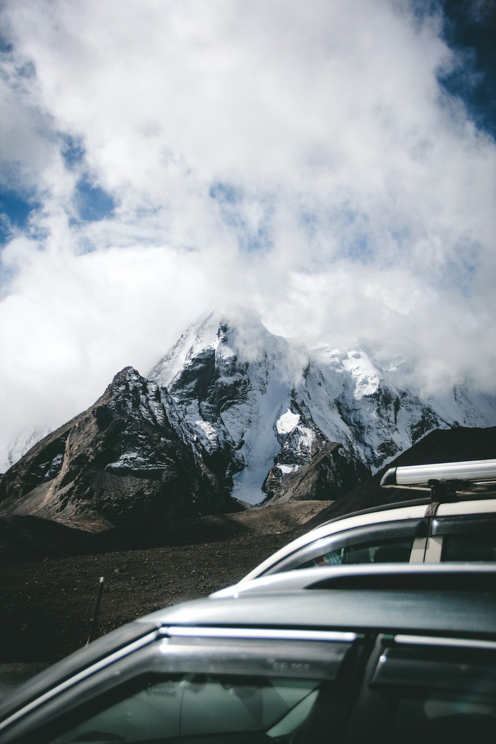 a car parked in front of a snow covered mountain