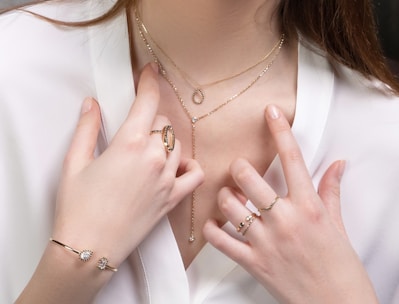 a close up of a person wearing rings and a necklace