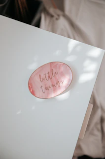 a white table with a pink plate with writing on it