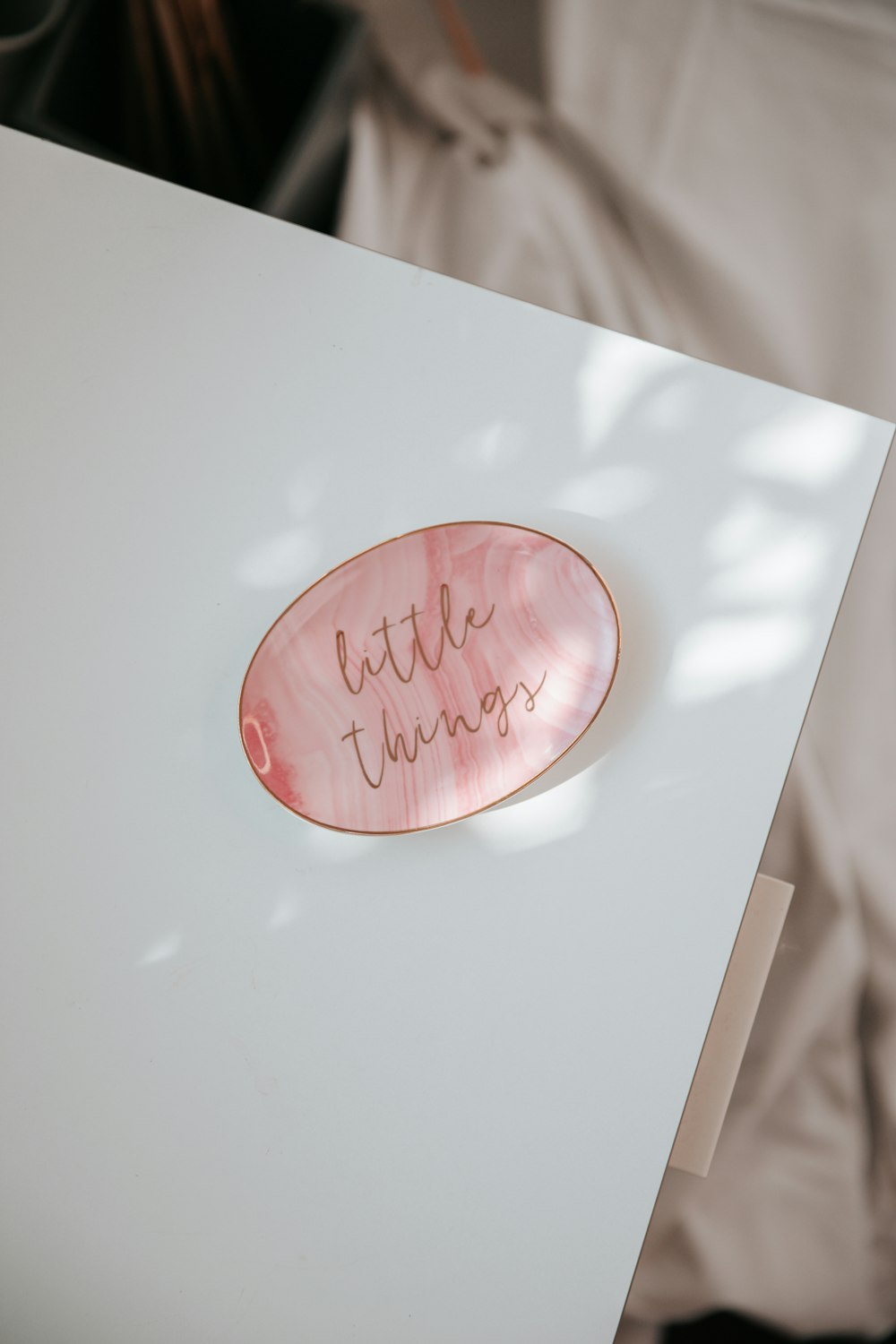 a white table with a pink plate with writing on it