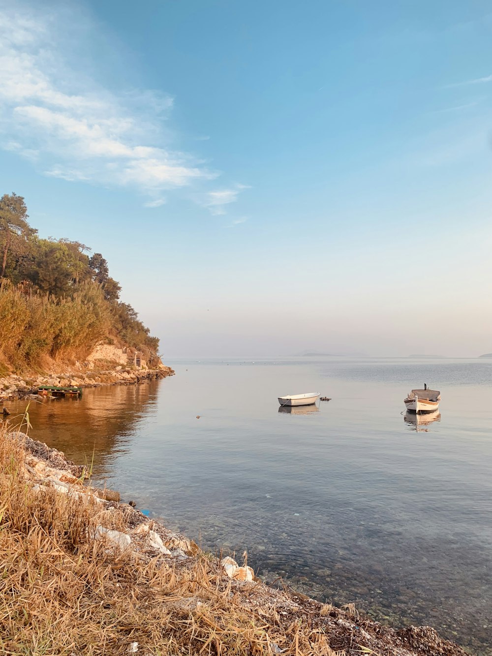 a couple of boats floating on top of a body of water