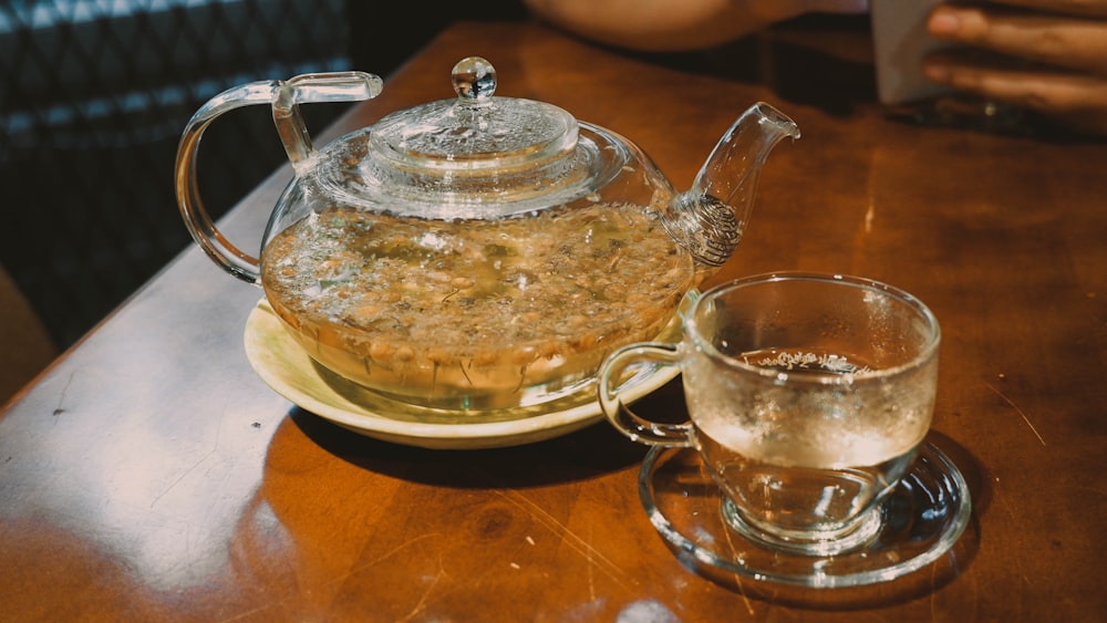 una tetera y una taza de vidrio sobre una mesa