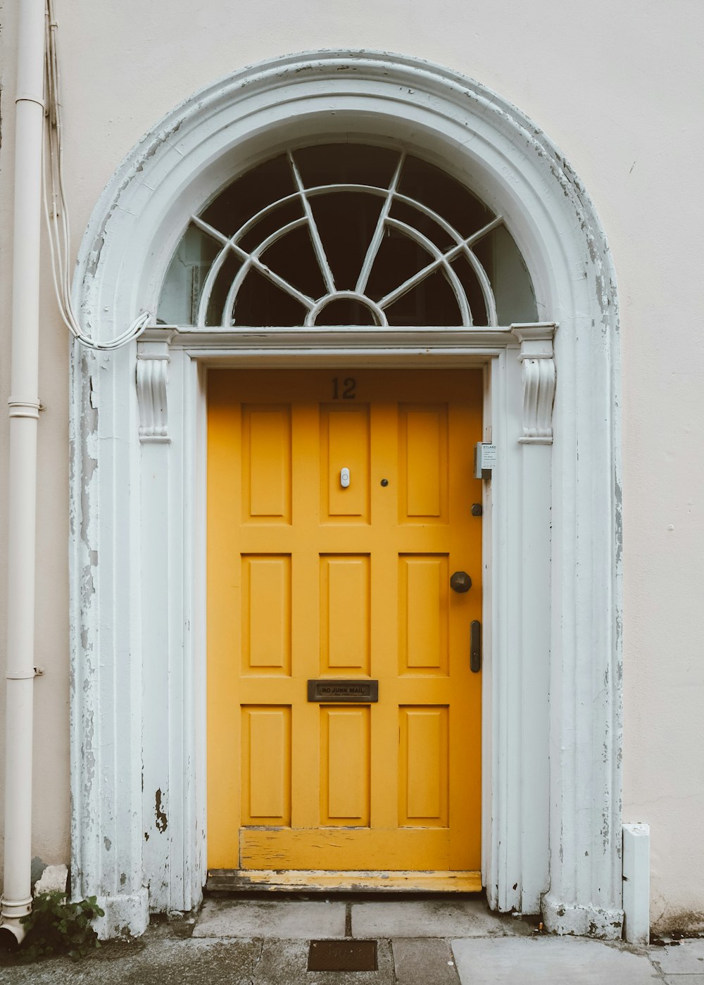 uma porta amarela com um arco branco acima dela