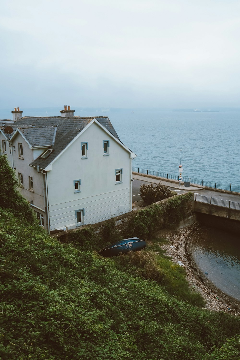 a house on a hill next to a body of water