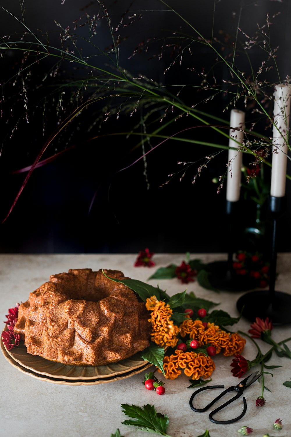 a cake on a plate next to a bottle of wine