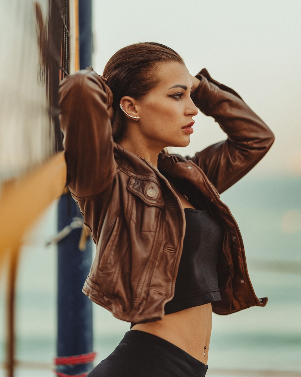 a woman in a leather jacket leaning against a wall