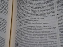 An instructor smiling while explaining a Bible passage with a group of attentive teens.