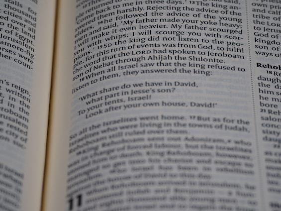 Open book displaying a passage from the Bible with a focus on the text centered on the page. The text is in black font on white paper, with some underlined words indicating emphasis.