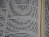 A close-up of a book's pages, with text detailing events from a biblical narrative about Solomon. The focus is on a section discussing Solomon's wealth, horses, and death.