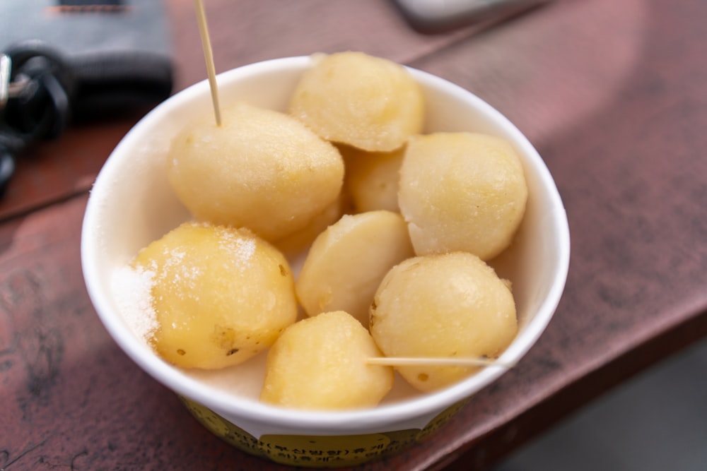 a white bowl filled with food on top of a wooden table