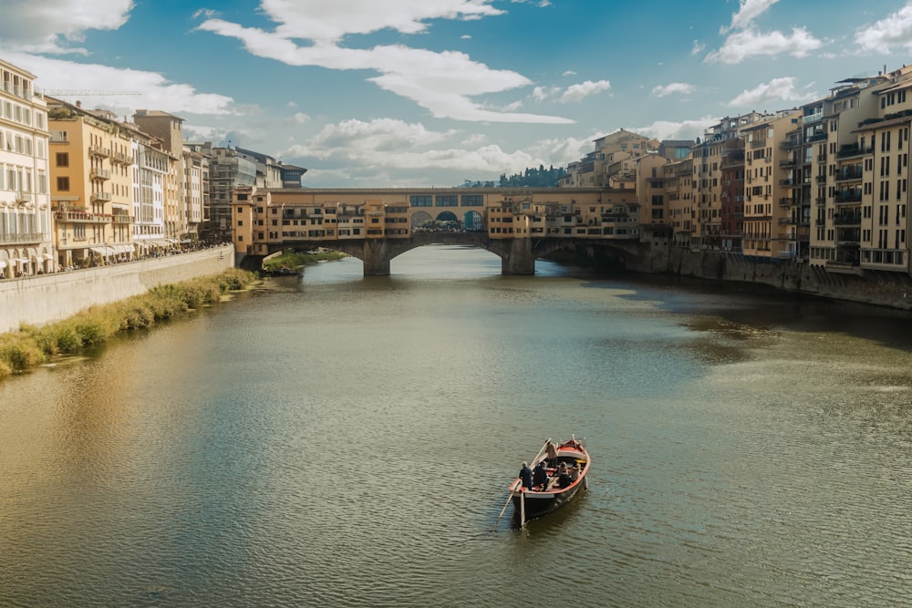 a boat traveling down a river next to tall buildings