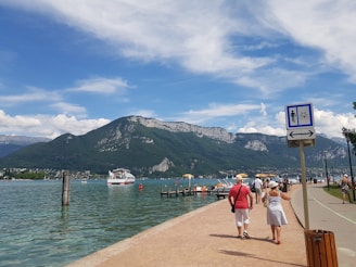 Two walkers engaging warmly with locals along the scenic shores of Lake Geneva during their awareness journey.
