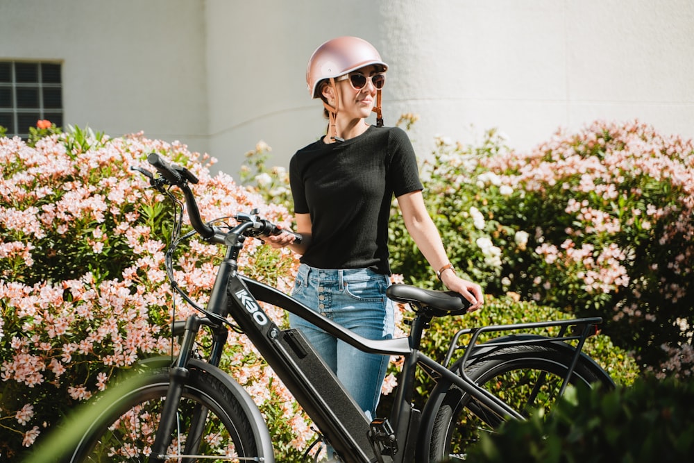 una donna che indossa un casco in piedi accanto a una bicicletta