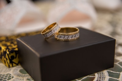 two wedding rings sitting on top of a black box