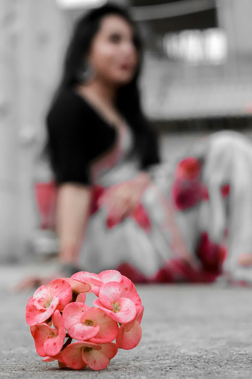 a woman sitting on the floor next to a bunch of flowers