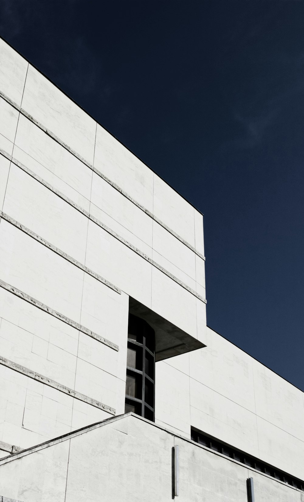 a tall white building with a clock on it's side