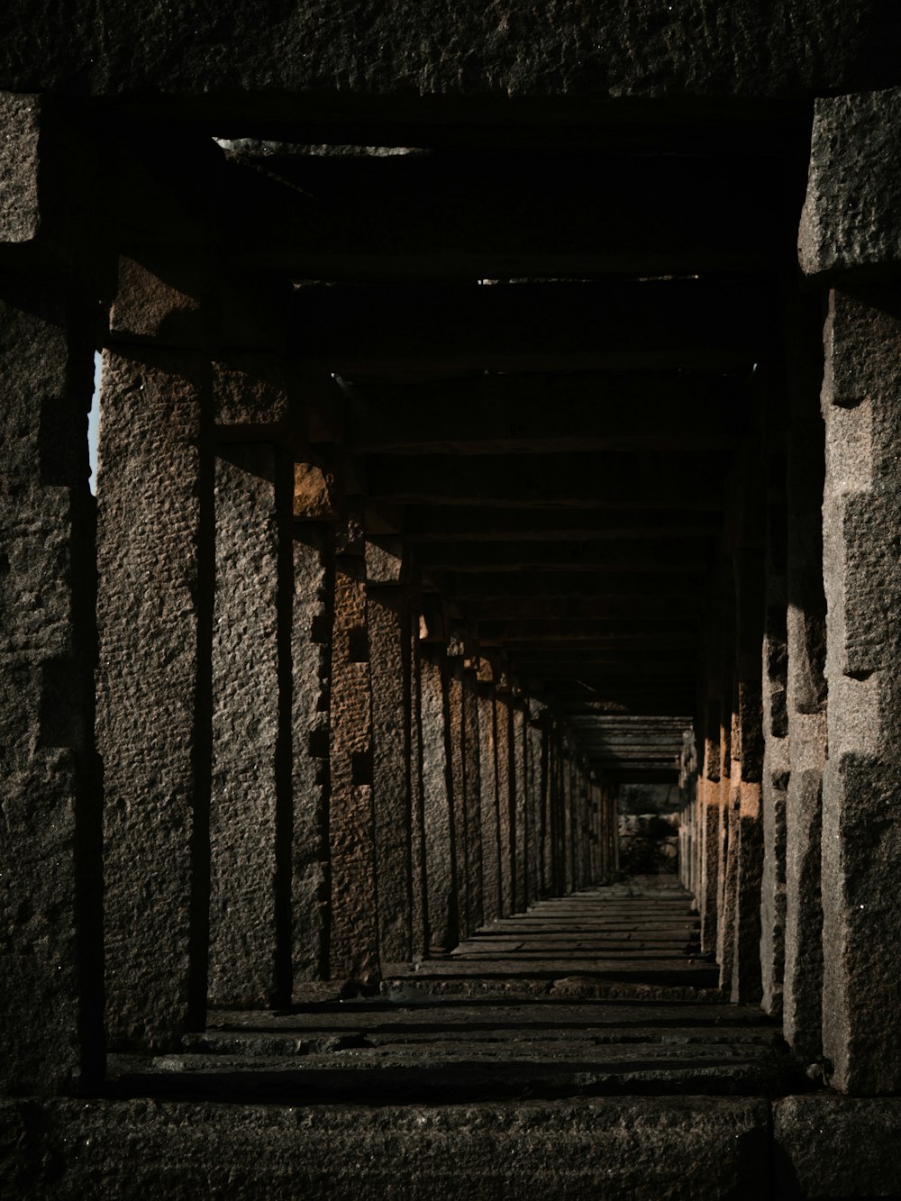 a long row of stone pillars in a building
