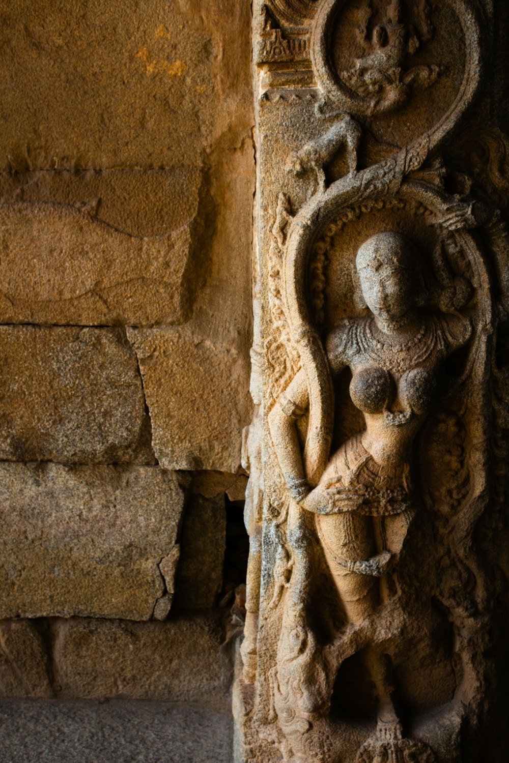 a stone carving of a person holding a vase