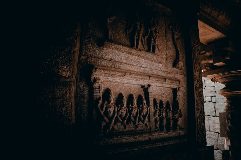 a stone wall with carvings on it in a dark room