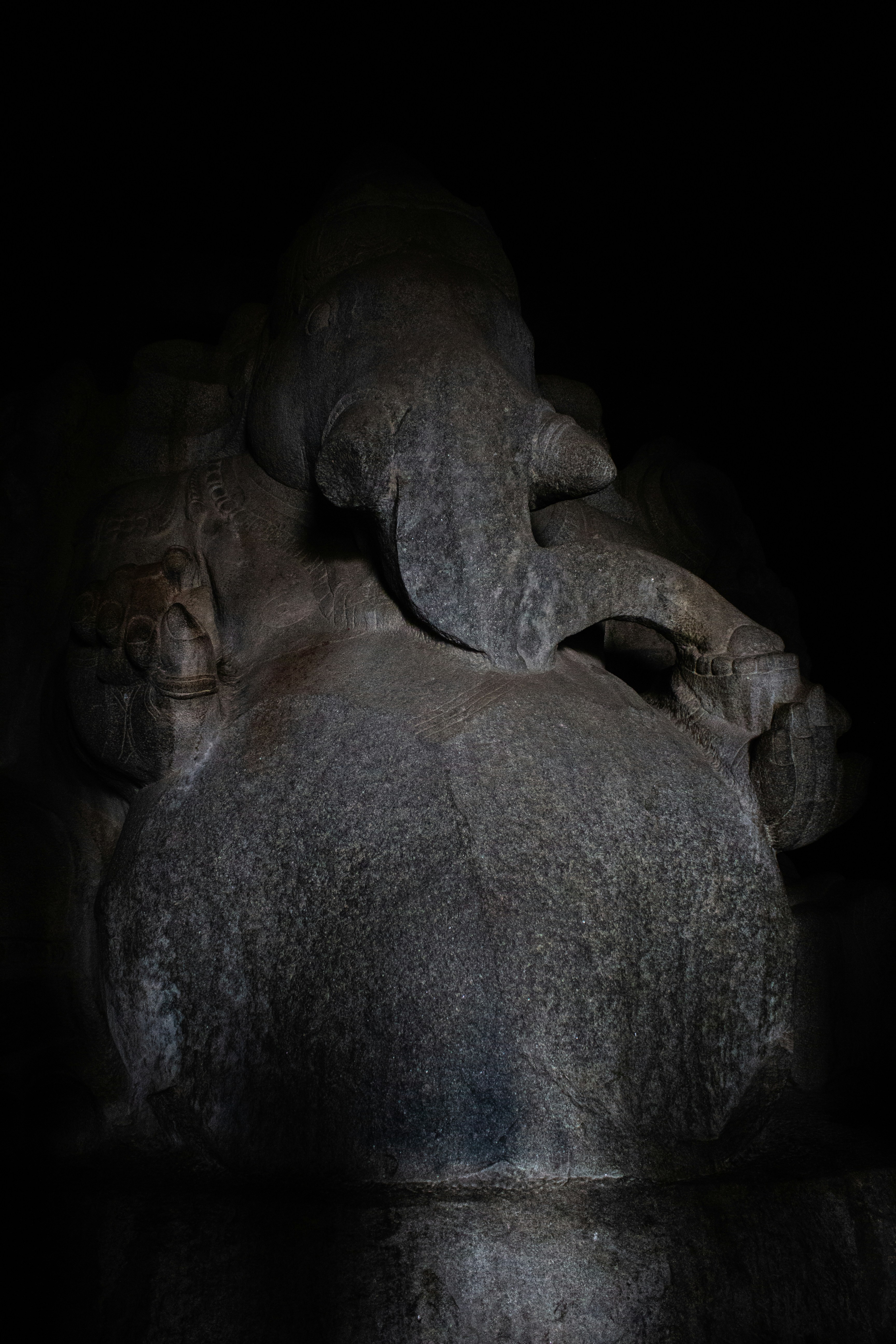 a large elephant laying on top of a rock