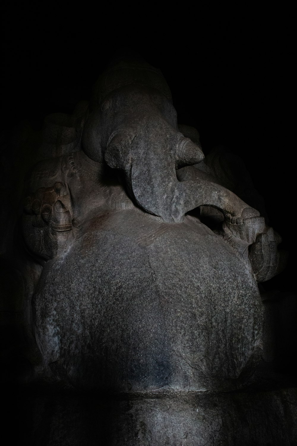 a large elephant laying on top of a rock