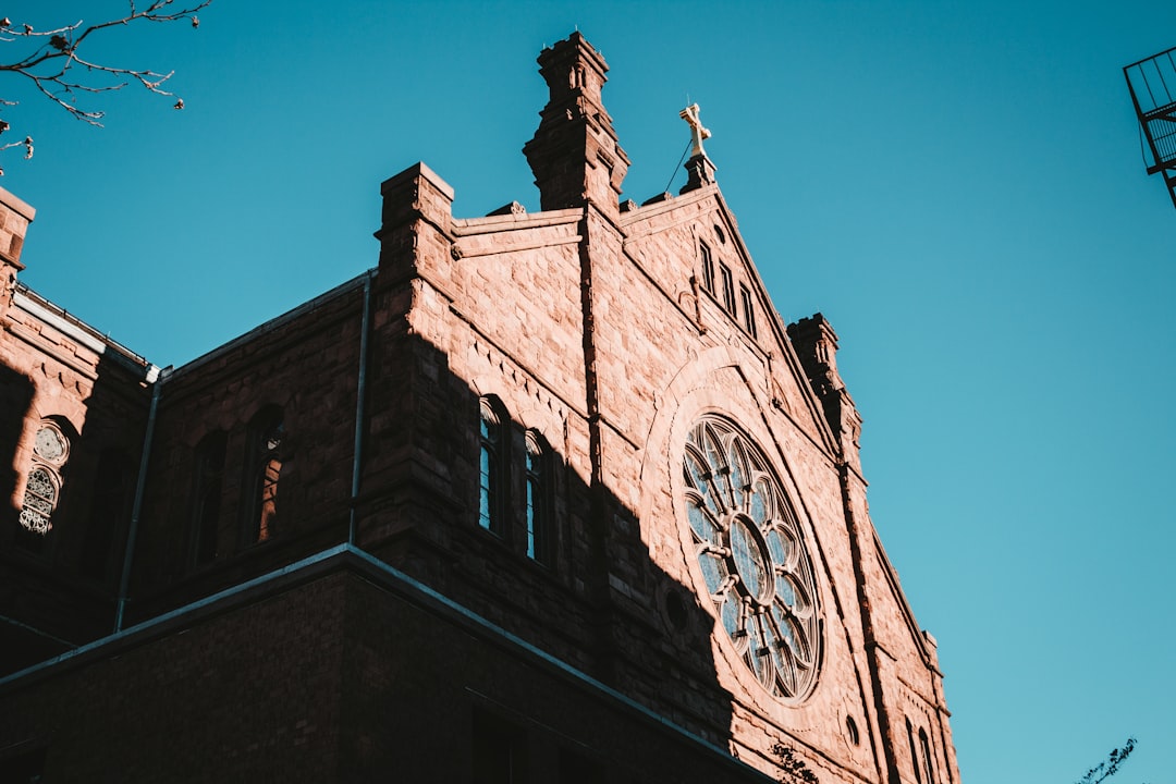 a tall building with a clock on the front of it, Sun rises on Cathedral in Providence.