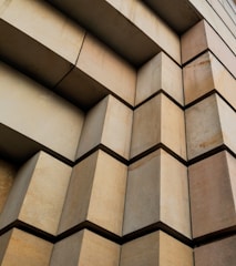 Close-up of brutalist facade featuring geometric concrete patterns and deep shadows.