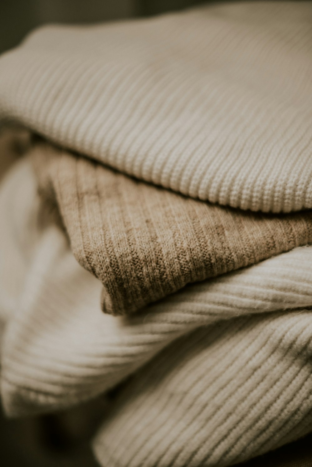 uma pilha de cobertores dobrados sentados em cima de uma mesa de madeira