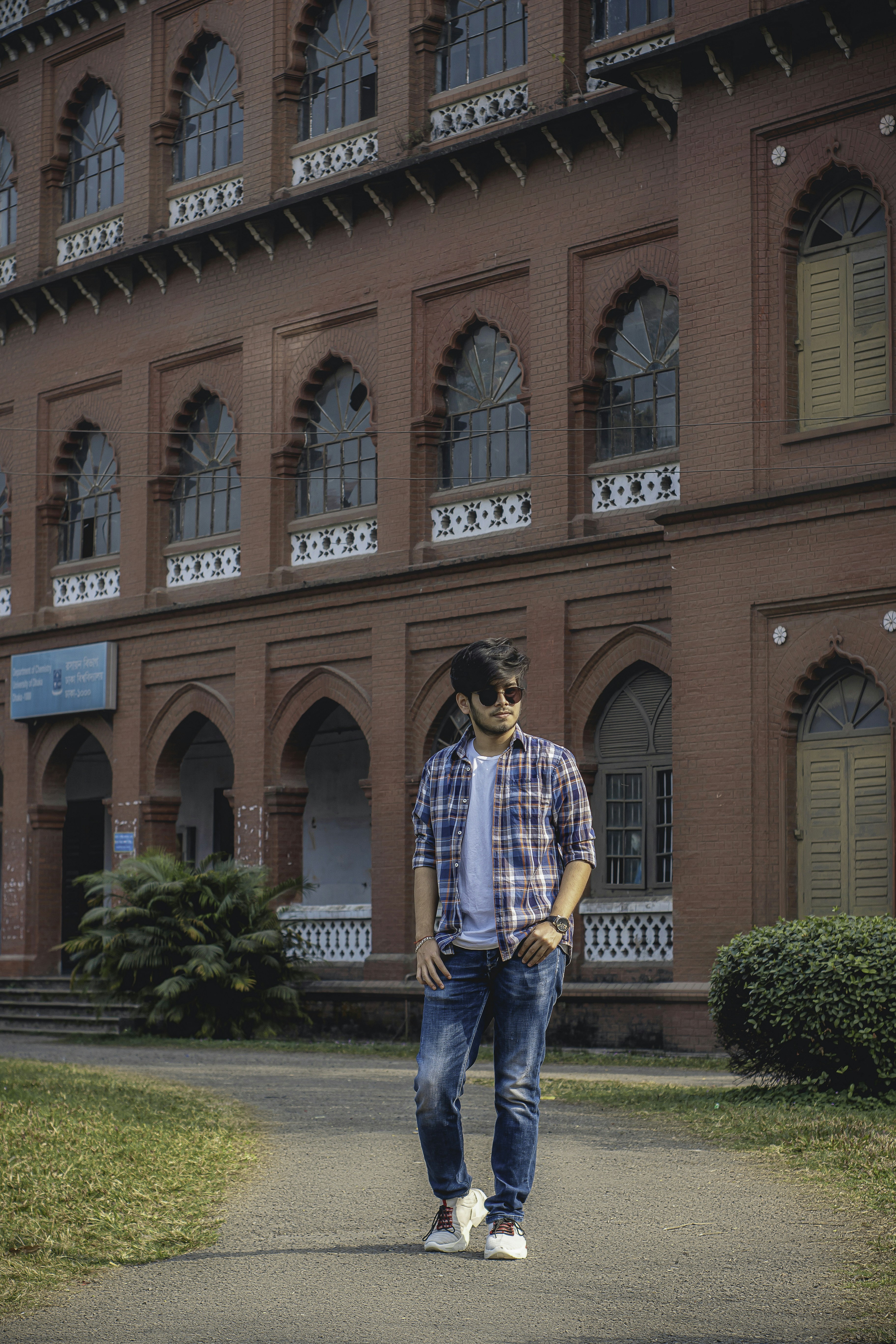 a man standing in front of a large building photo – Free Grey Image on ...