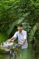 a man riding a bike through a lush green forest