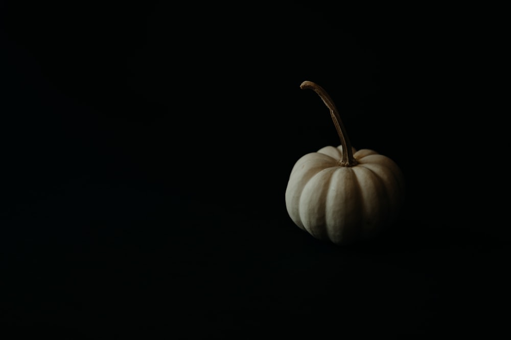 a white pumpkin sitting on top of a black table