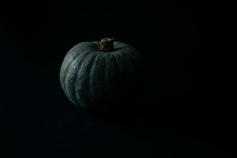 a large green pumpkin sitting on top of a black table