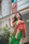 Happy customer draped in a pastel cotton saree standing in a sunlit garden.