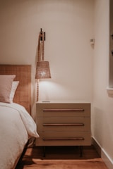 a bedroom with a bed, nightstand, and lamp