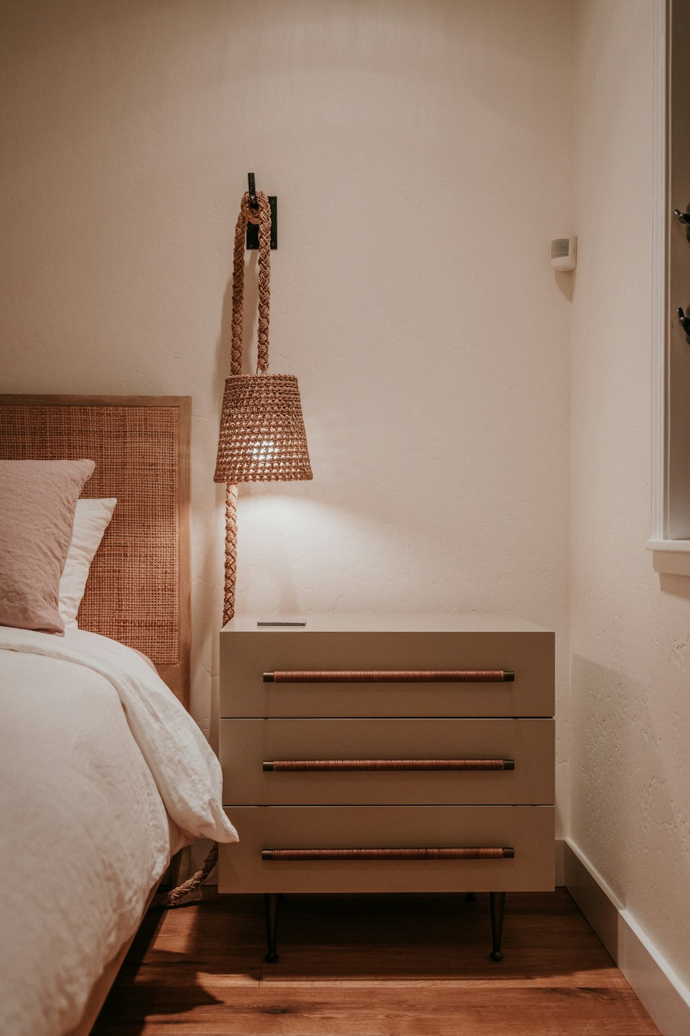 a bedroom with a bed, nightstand, and lamp